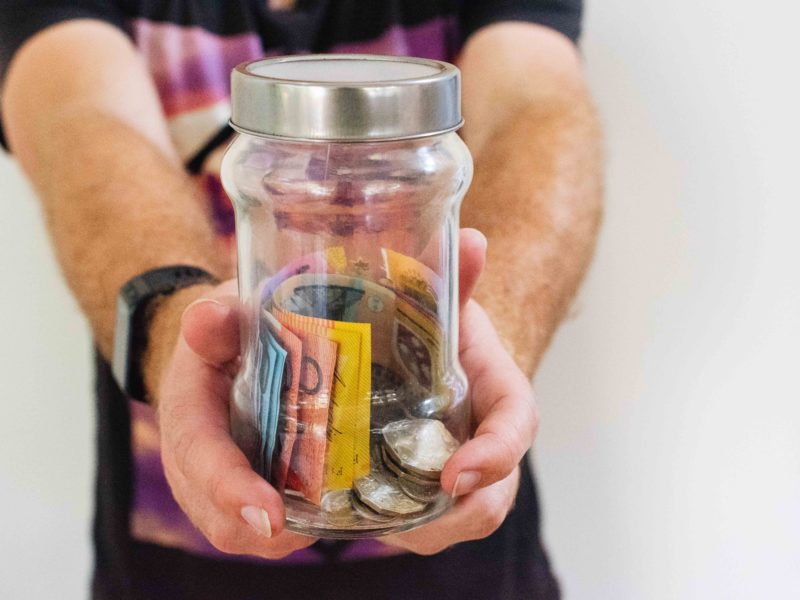 Hand Of A Male Holding A Money Jar - Latest Cannabis News Australia - Cannabiz